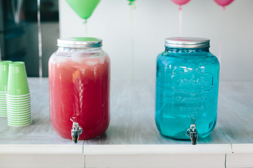 Simple blue & pink drinks for gender reveal party. Water in blue tinted mason jar & pink lemonade in clear mason jar. - Gender Reveal Party Ideas by Utah mom blogger By Jen Rose
